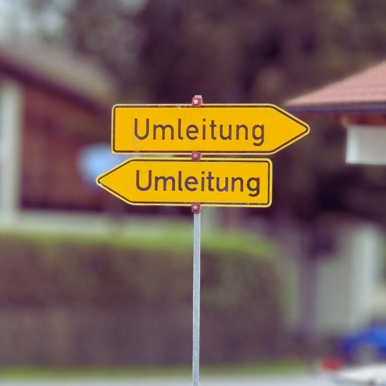 Gelbe Schilder mit dem Wort "Umleitung" in beide Richtungen.