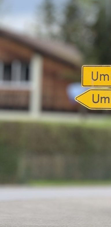 Umleitung Wegweiser mit zwei Richtungspfeilen, auf einem ländlichen Hintergrund.